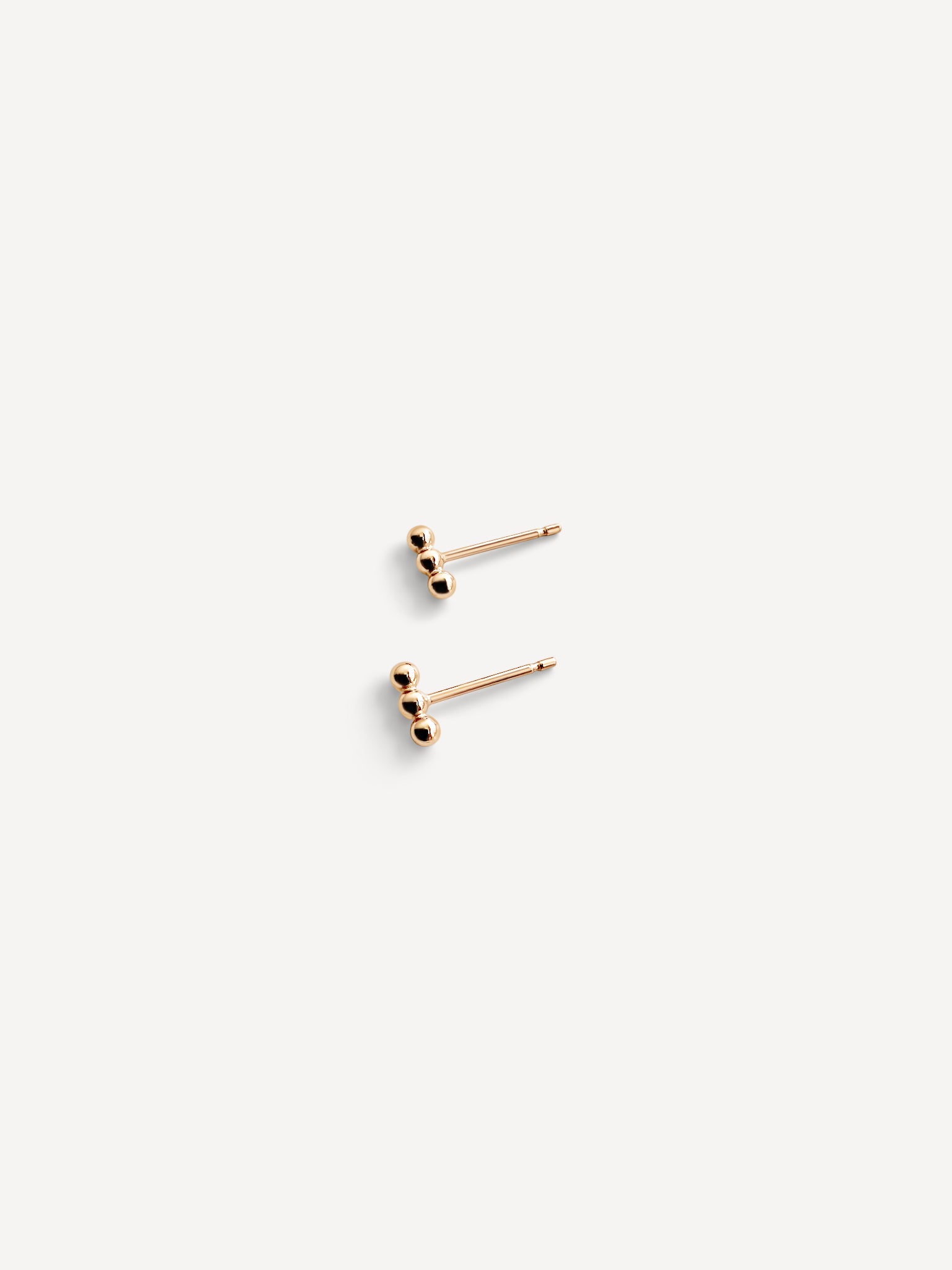 Close-up of the Lily Dot Bar Studs in gold fill, showcasing their delicate dot design and sleek finish.