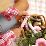 Manuka Honey & Rose Tallow Hand Balm held beside a picnic basket