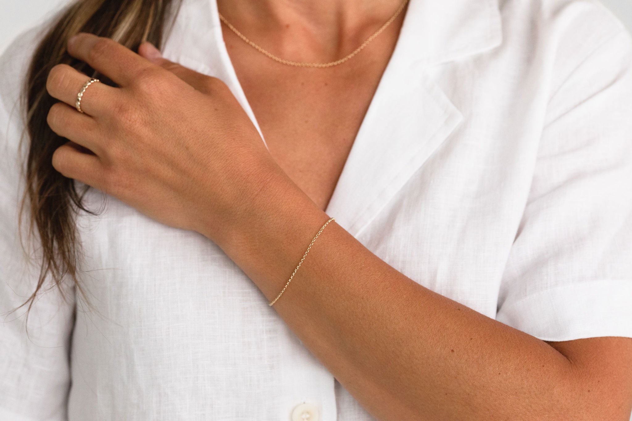 Model styling a dainty gold chain bracelet by Sheena Marshall Jewelry, perfect for refined everyday wear.