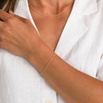 Model styling a dainty gold chain bracelet by Sheena Marshall Jewelry, perfect for refined everyday wear.