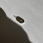Molten Form Pendant Necklace No. 2, Sterling Silver — pendant close-up on linen