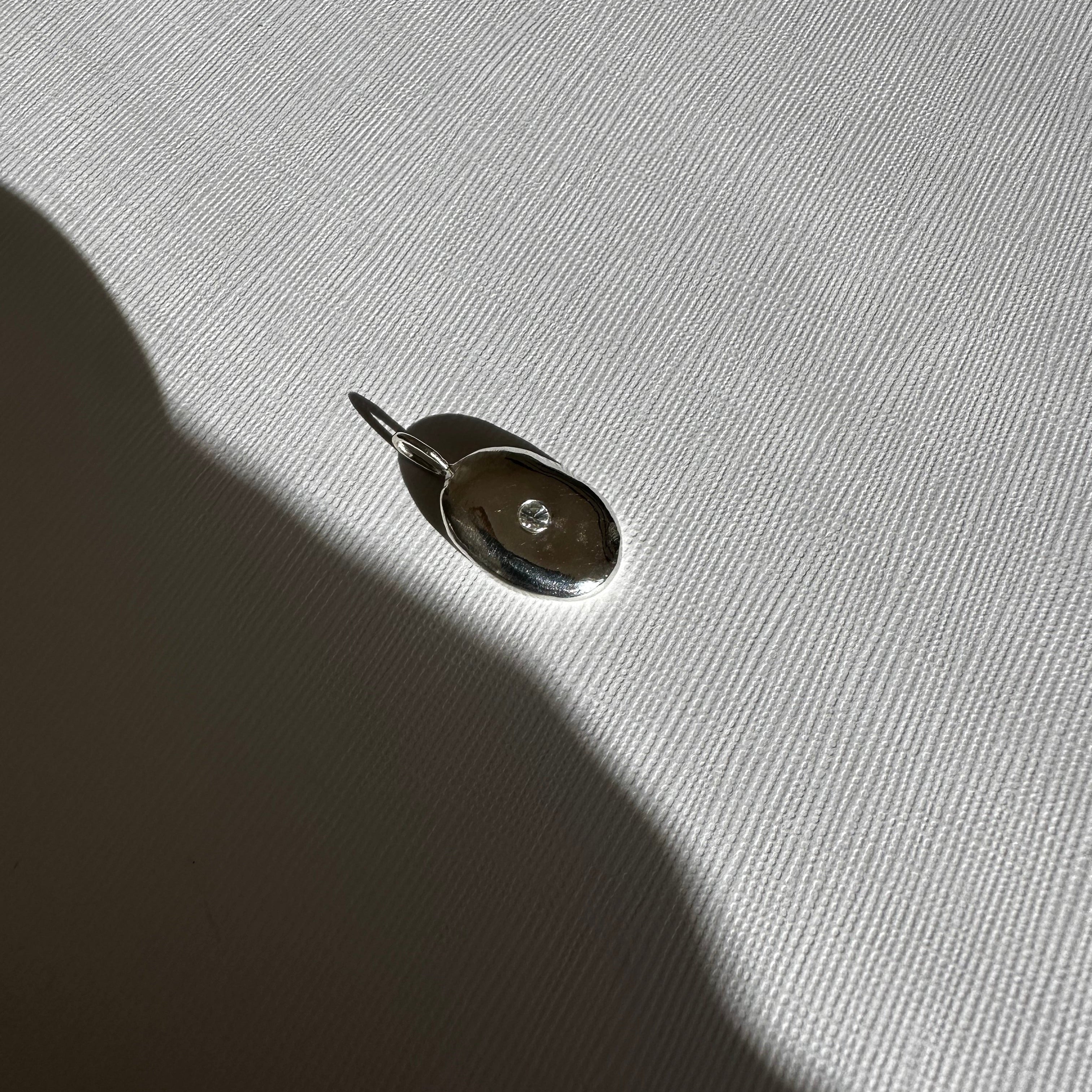 Molten Form Pendant Necklace No. 2, Sterling Silver — pendant close-up on linen