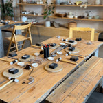 A participant focused on crafting a silver ring during a hands-on jewelry class.