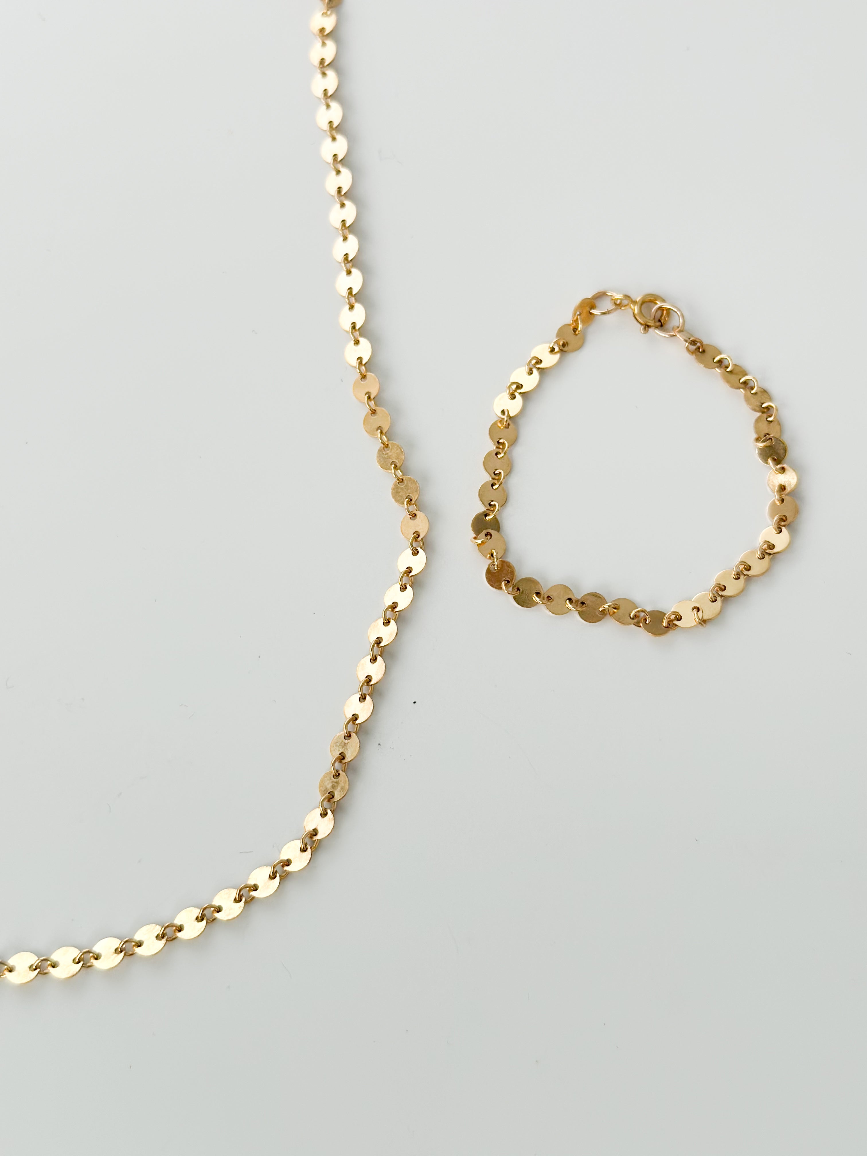 Gold-filled Petite Disc Bracelet and Necklace set by Sheena Marshall Jewelry, featuring delicate, light-catching discs for a cohesive and refined style.