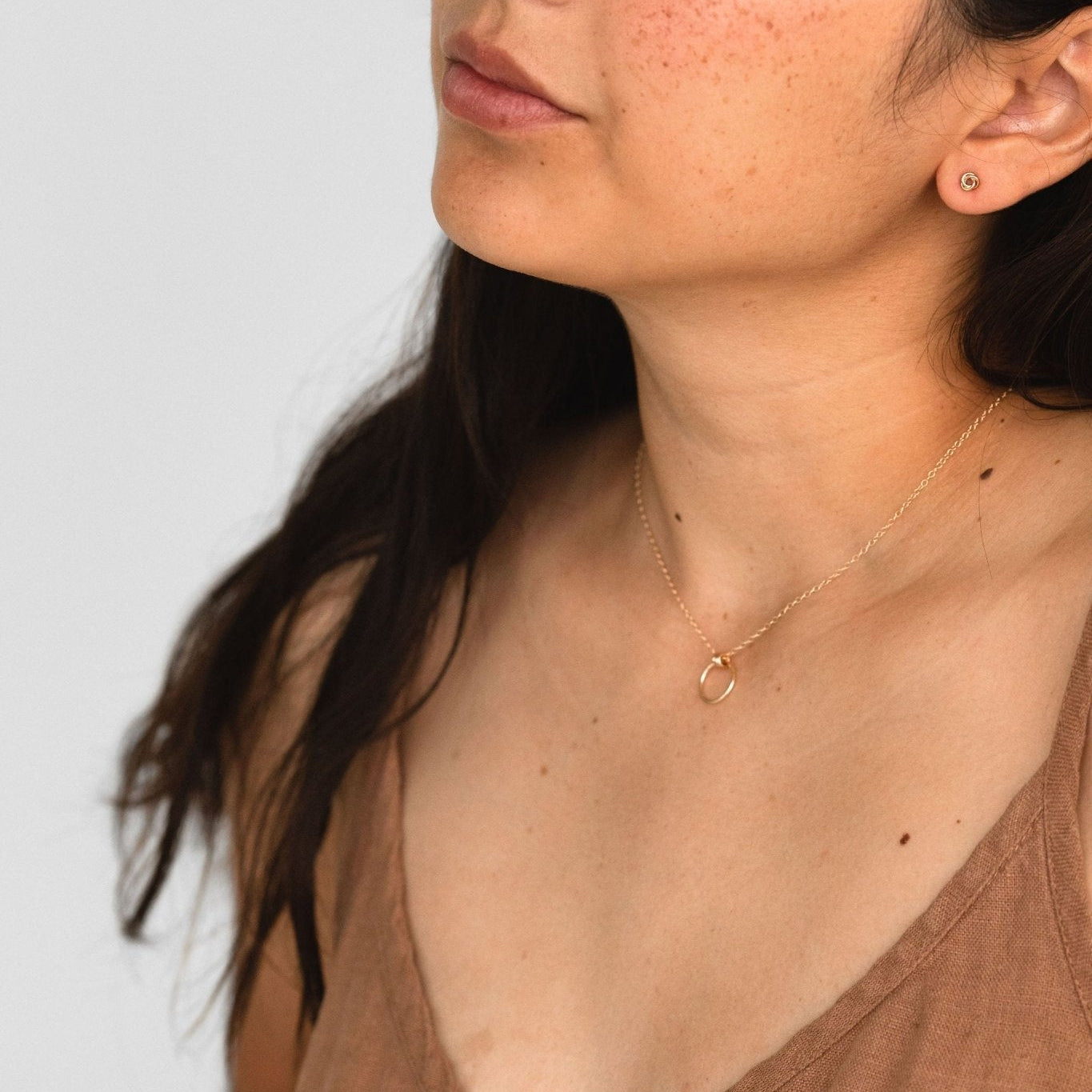 Model wearing Petite Knot Studs in sterling silver, showcasing their delicate and timeless design.