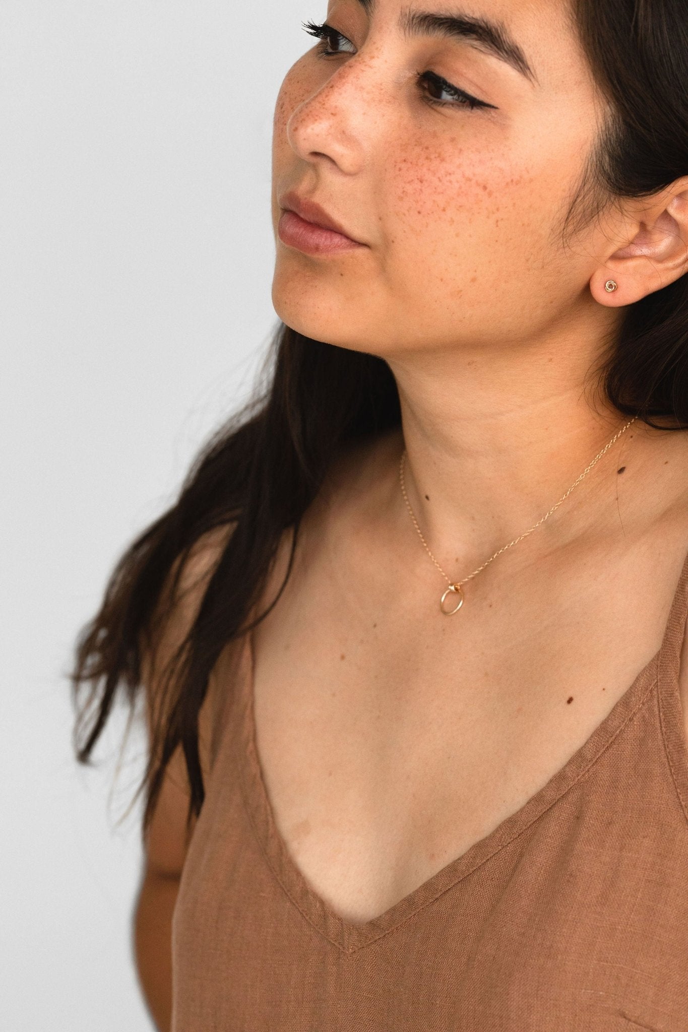 Model wearing Petite Knot Studs in sterling silver, showcasing their delicate and timeless design.