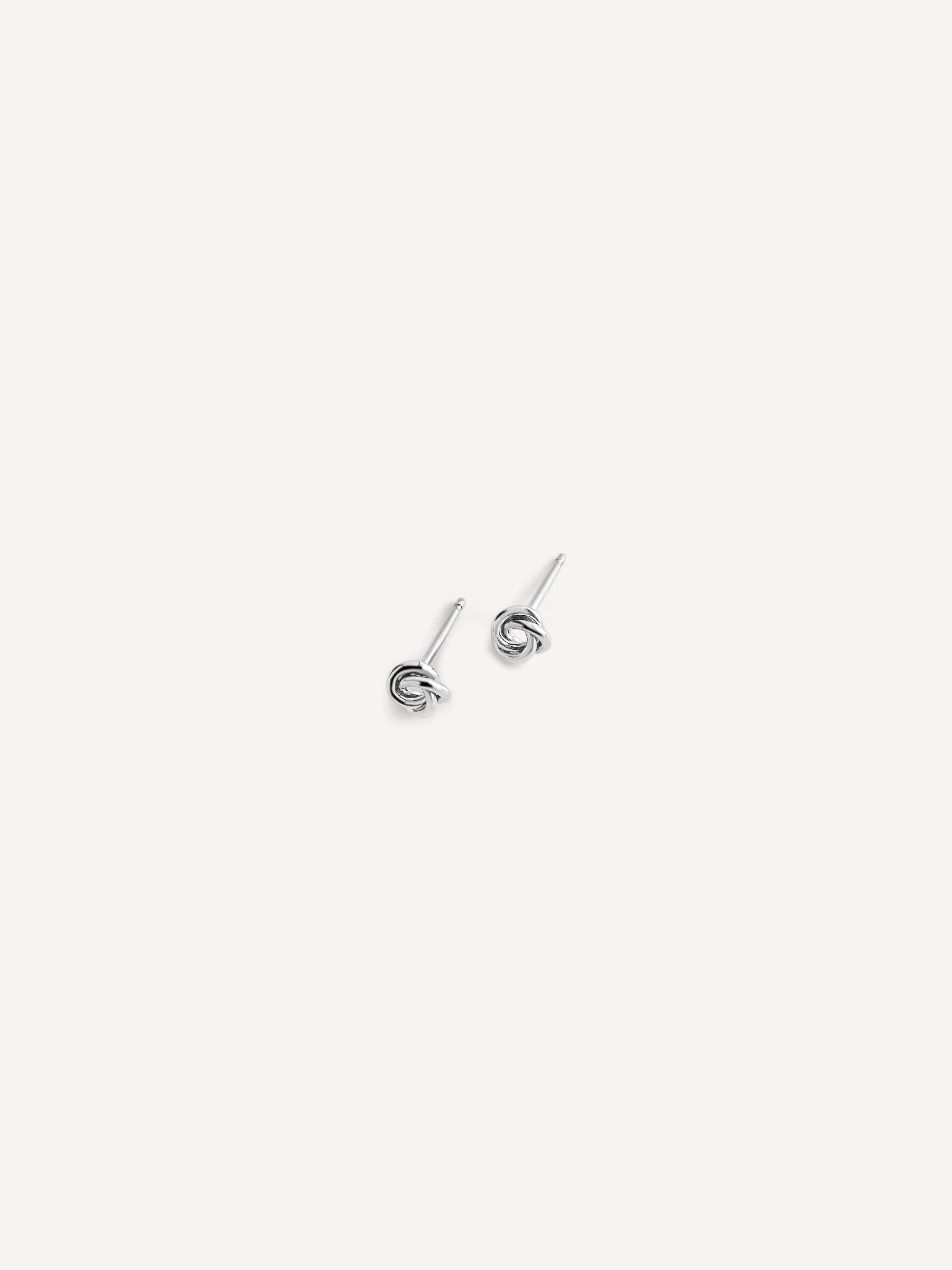 Side view of Petite Knot Studs in sterling silver, highlighting their minimalist knot design.