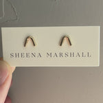 Handcrafted 14k gold arch stud earrings by Sheena Marshall Jewelry, measuring 7mm in height and 8.5mm in width, featuring an architectural design for refined casual elegance and heirloom quality shown on jewelry card.