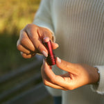 Rose Tallow Lip Balm - TINTED held in a hand