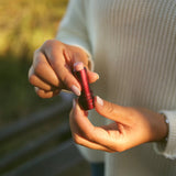 Rose Tallow Lip Balm - TINTED held in a hand