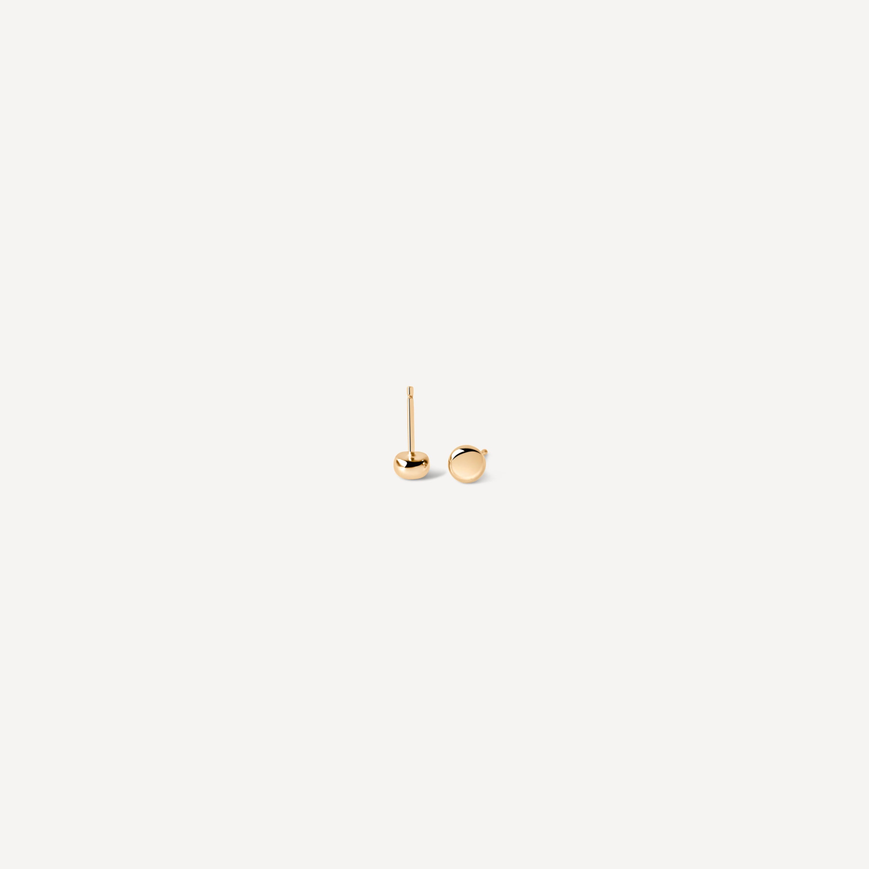 Simple gold seed studs at angle, displaying perfect sphere design for minimalist jewelry lovers seeking timeless pieces