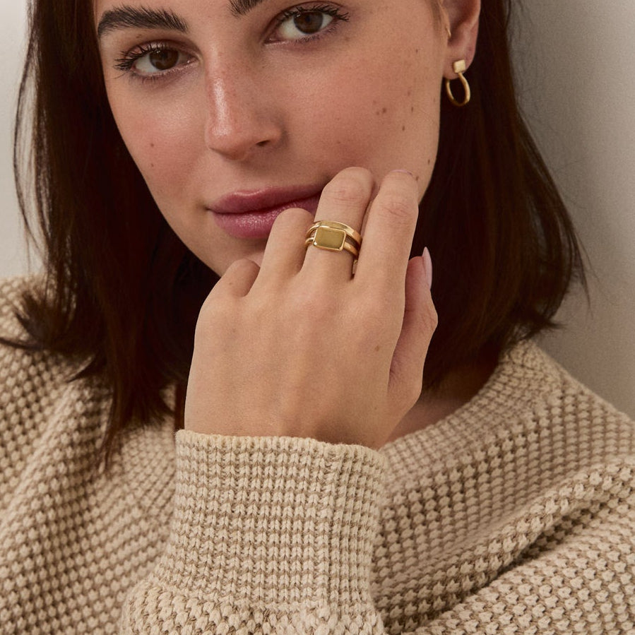 Woman wearing a beige sweater against a plain background