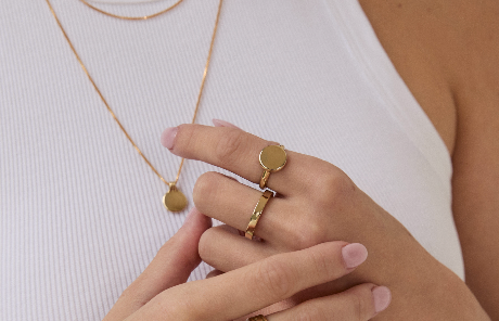 Stacked Forma Coin Ring with other gold jewelry, showing its versatile and classic look.