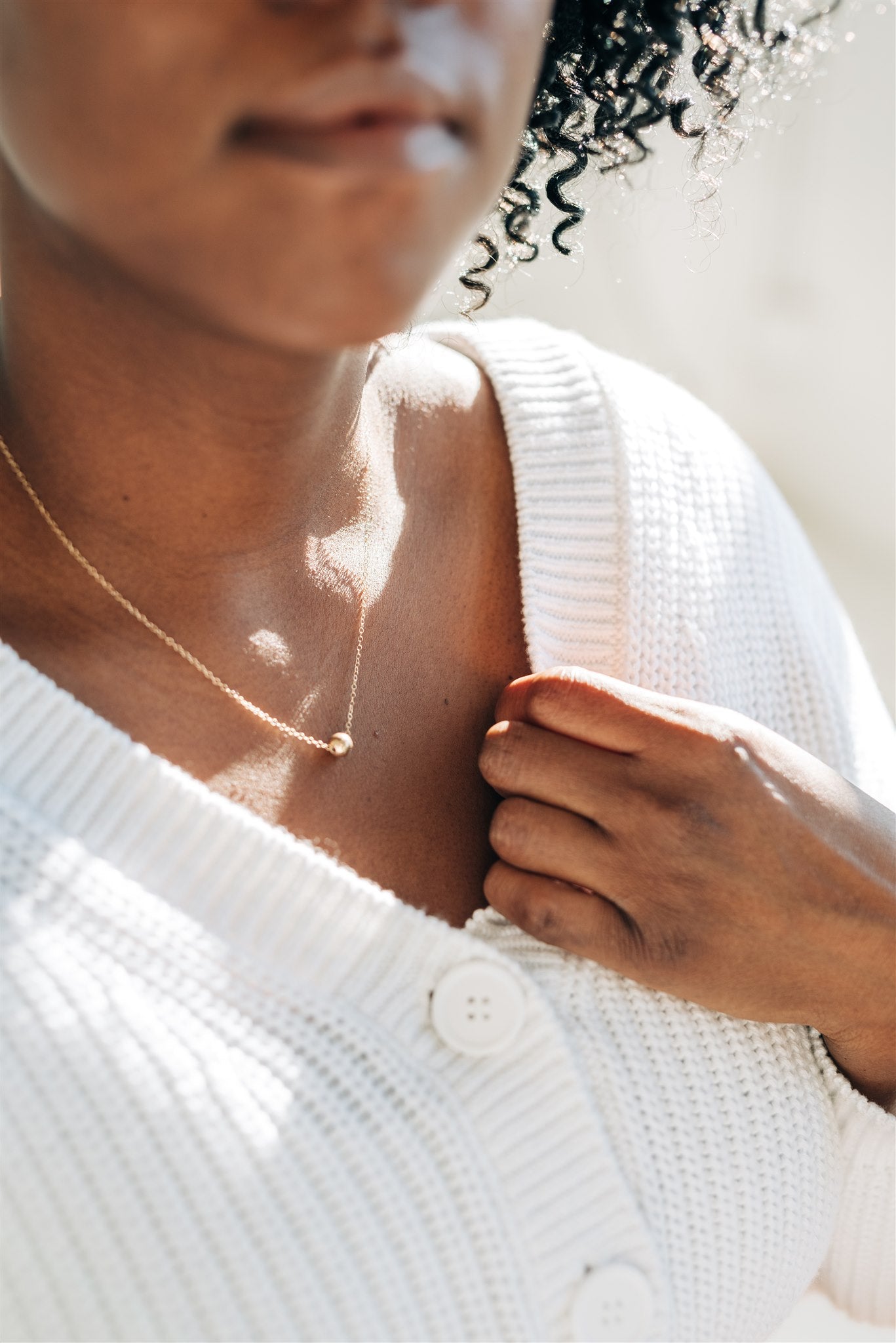 lose-up of the Nova Floating Sphere Necklace showing the polished gold fill sphere detail.