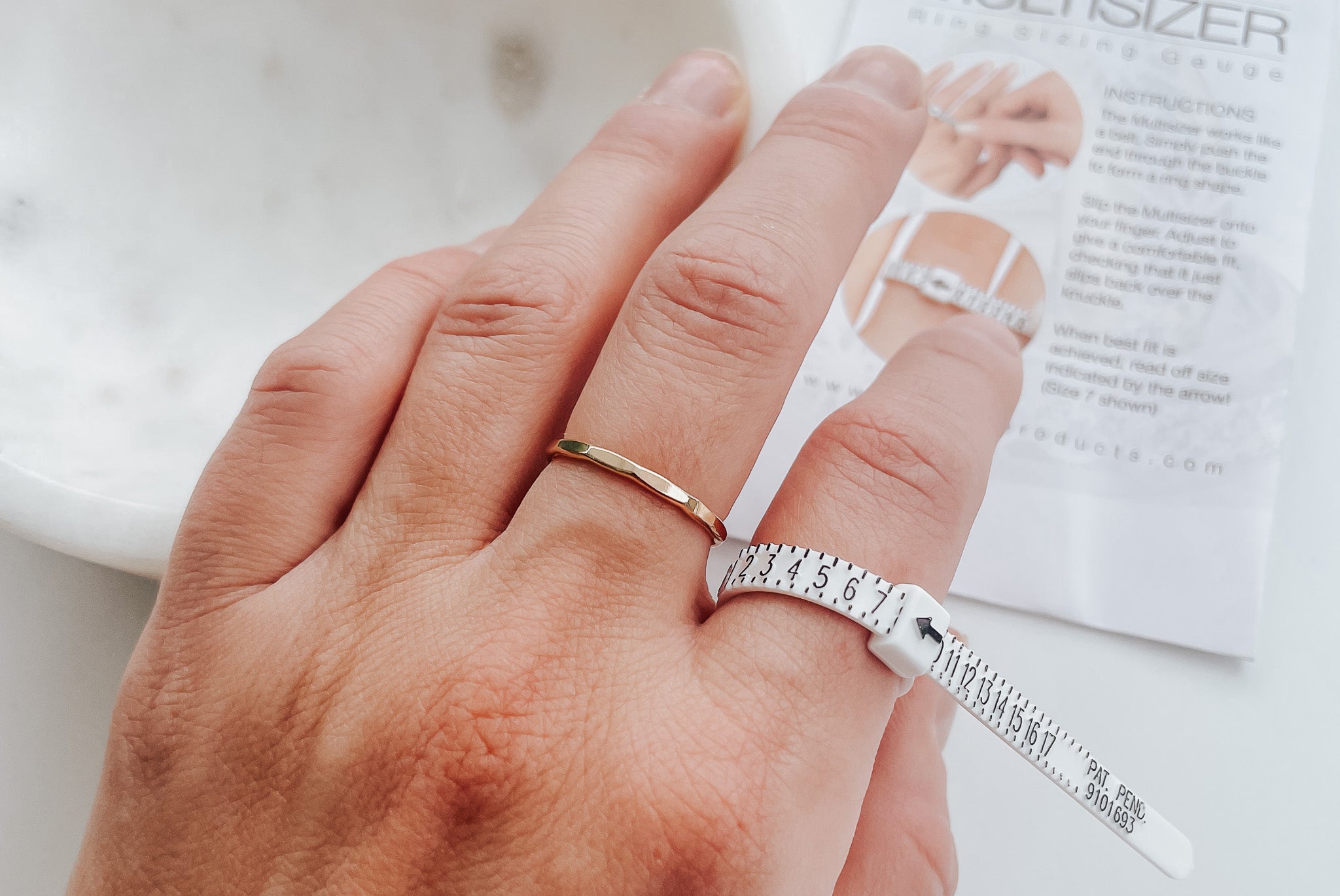 Close-up of Ring Sizer on hand measuring ring size.