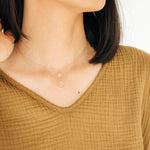 Woman wearing the Sol Circle Pendant Necklace layered with another necklace.