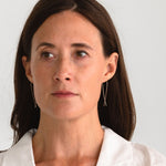 Woman wearing gold fill long threader earrings, showcasing the elegant and minimalist profile.
