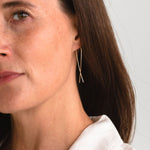 Woman wearing gold fill long threader earrings, showcasing the elegant and minimalist profile.