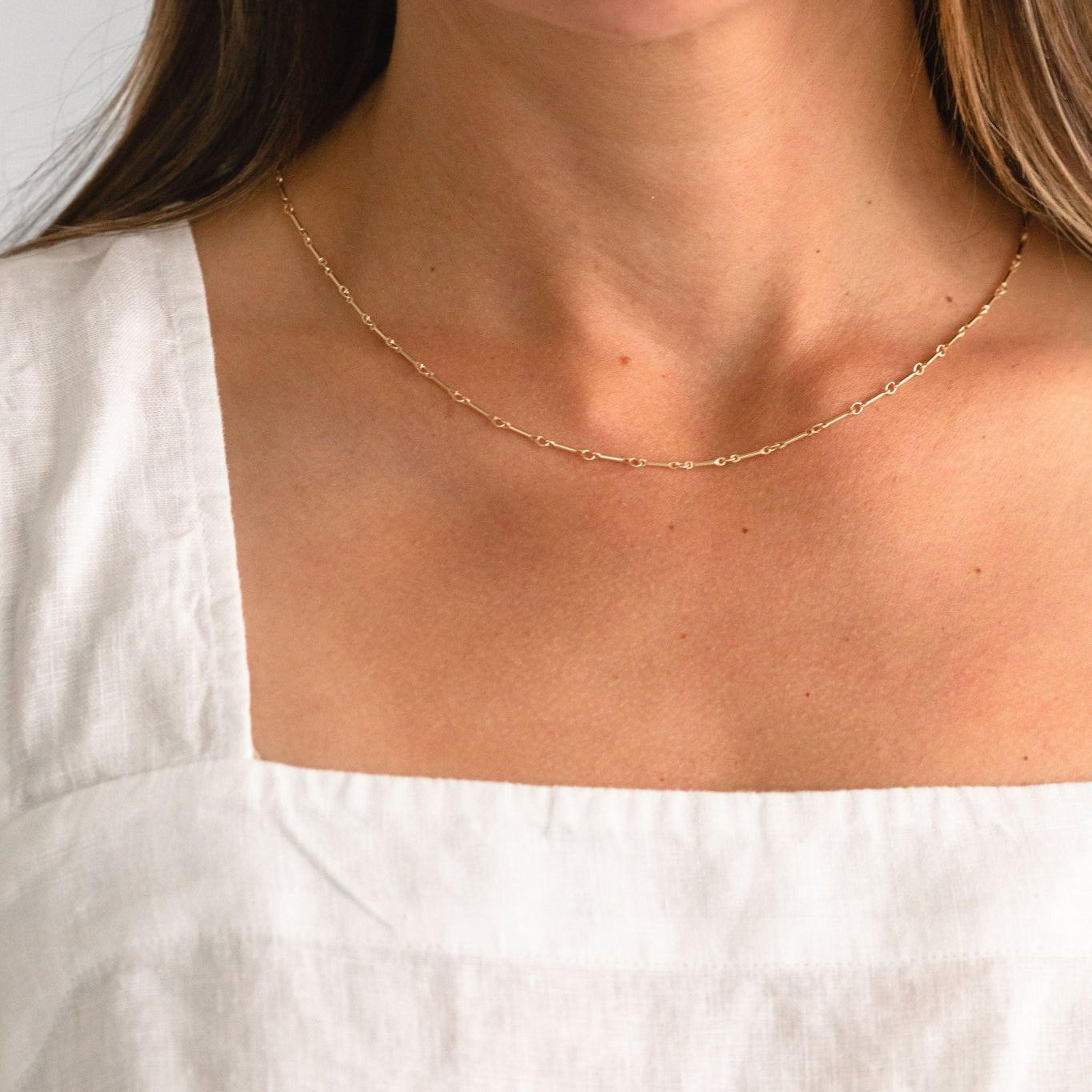 Handcrafted Alice gold link necklace by Sheena Marshall Jewelry, shown worn on a woman’s neck, highlighting its delicate, minimalist design in 14k gold fill for everyday elegance and layering.