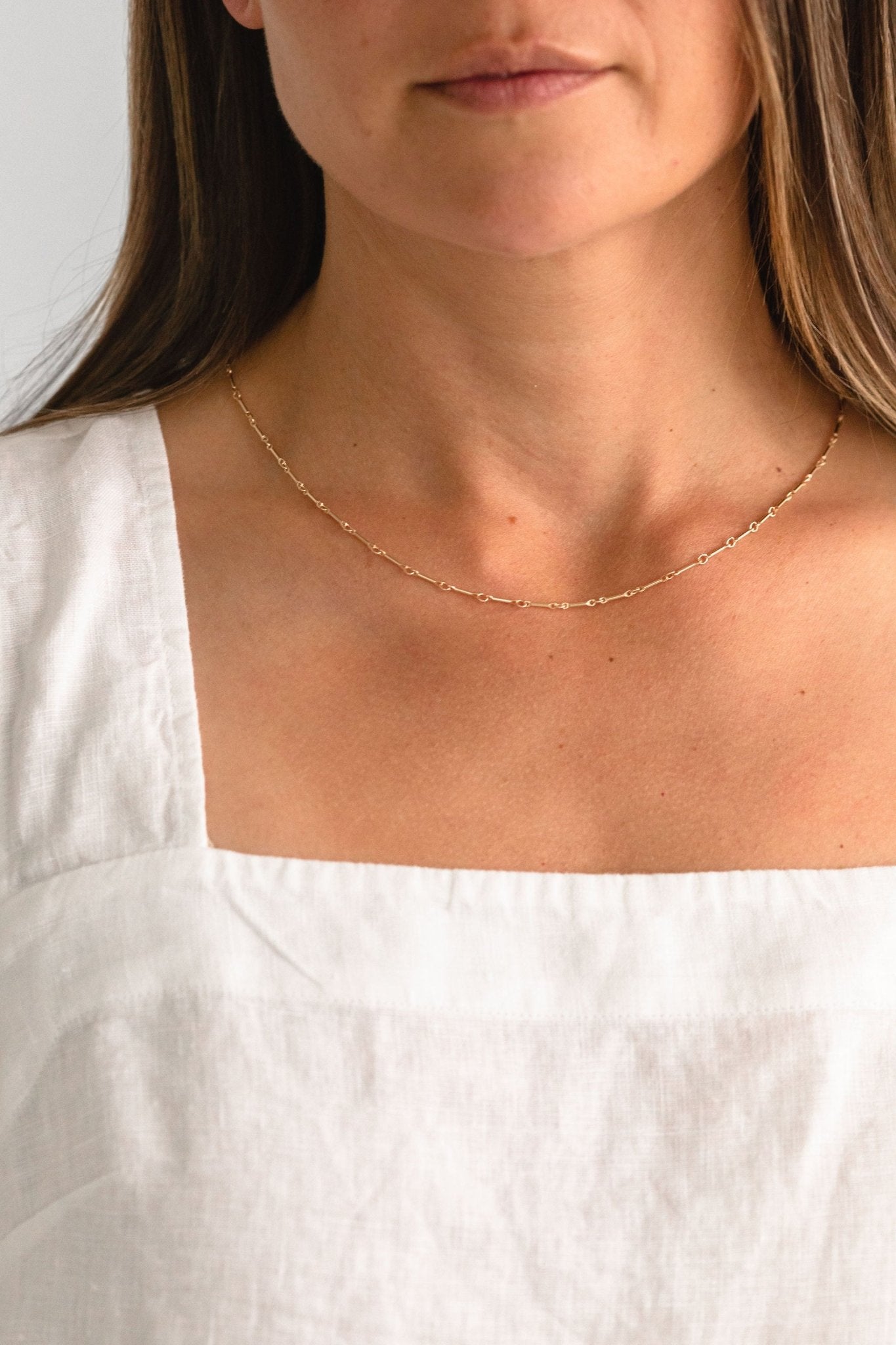 Handcrafted Alice gold link necklace by Sheena Marshall Jewelry, shown worn on a woman’s neck, highlighting its delicate, minimalist design in 14k gold fill for everyday elegance and layering.