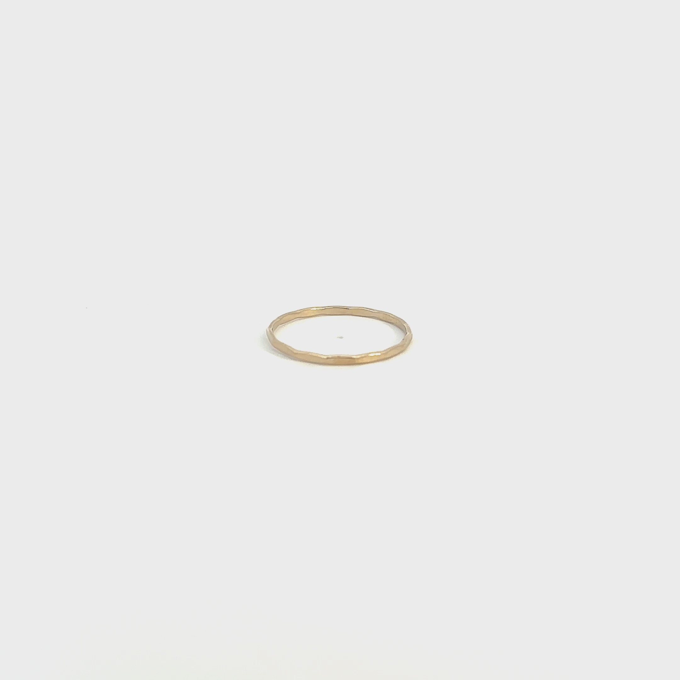 Adorn your hand with a delicate, shimmering gold stacking ring.