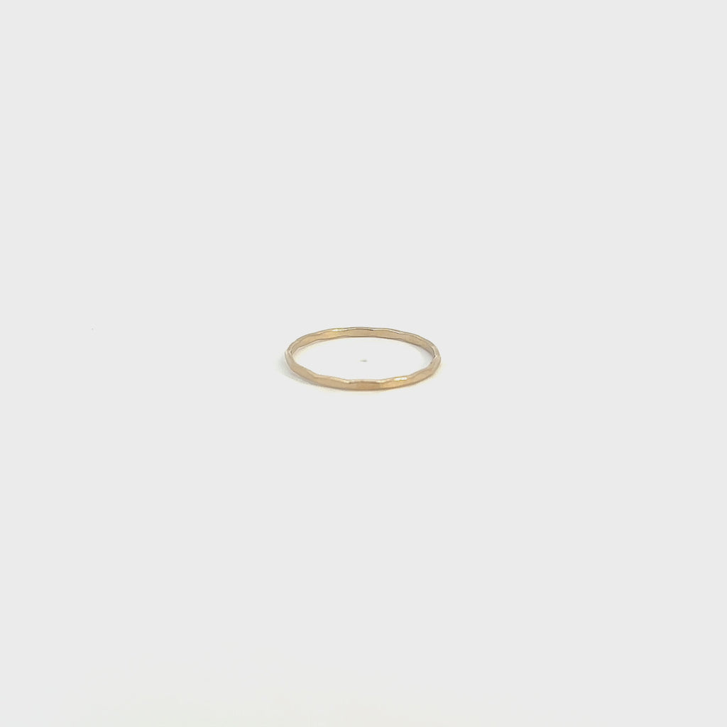 Adorn your hand with a delicate, shimmering gold stacking ring.