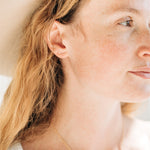 Model showcasing handcrafted Bowery Bar Studs in gold fill by Sheena Marshall Jewelry, highlighting their minimalist design and versatility for everyday elegance.