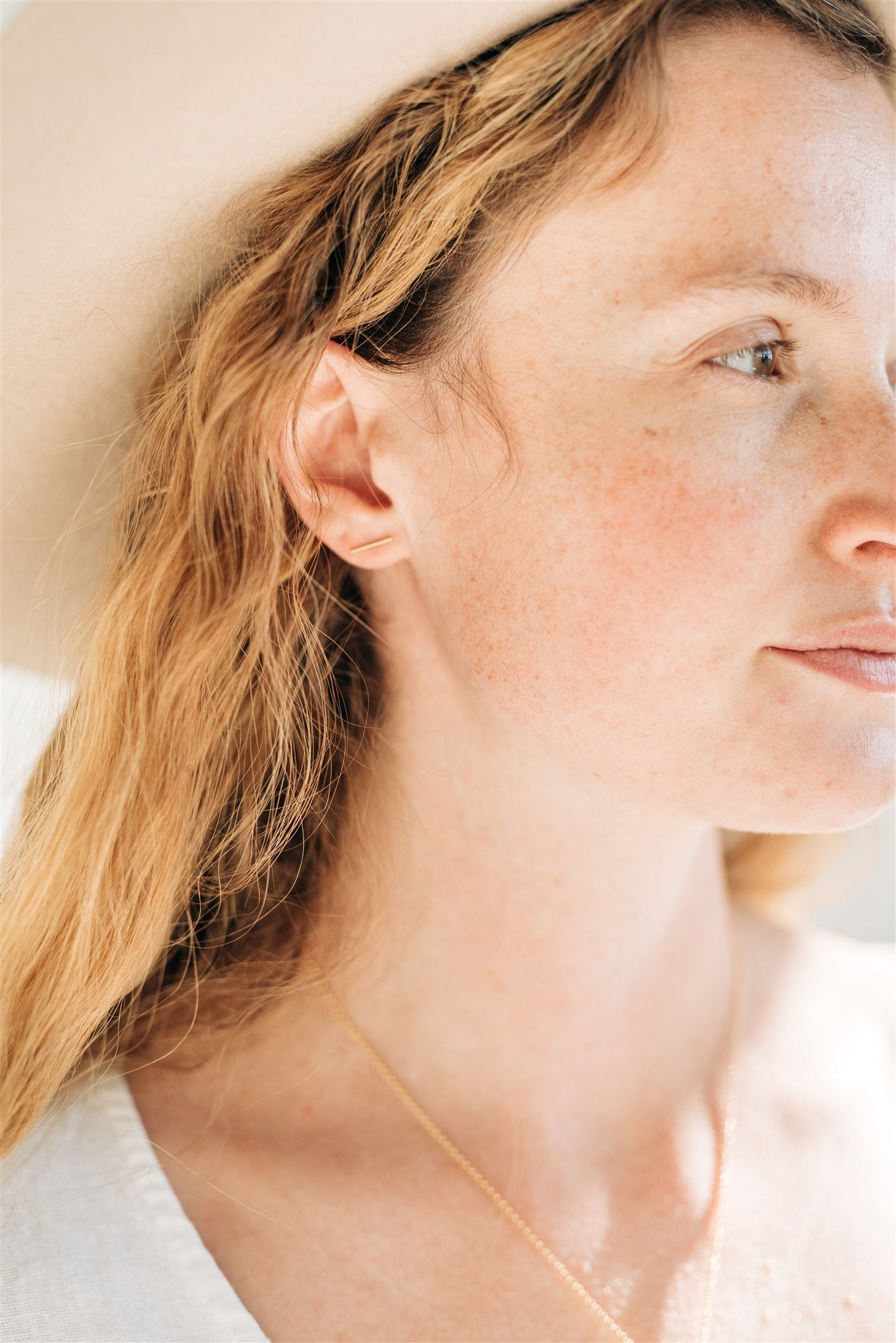 Model showcasing handcrafted Bowery Bar Studs in gold fill by Sheena Marshall Jewelry, highlighting their minimalist design and versatility for everyday elegance.