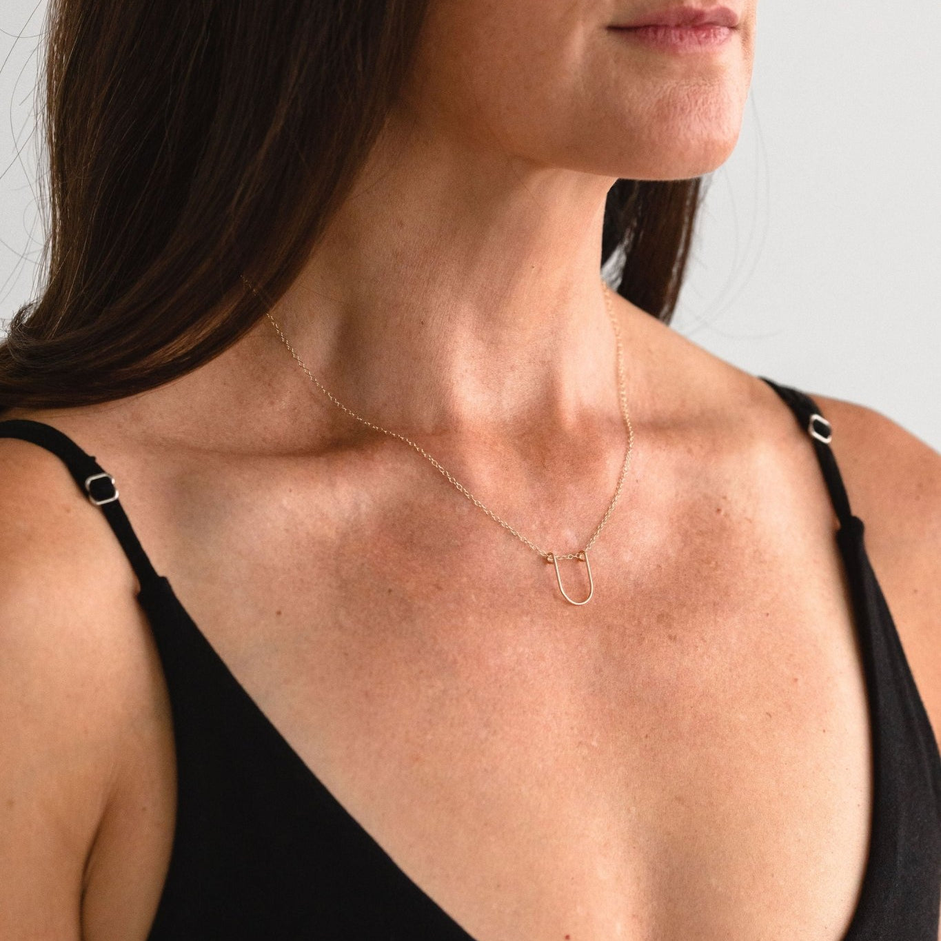 Gold-filled Empower Arch Necklace worn by a model, front view.