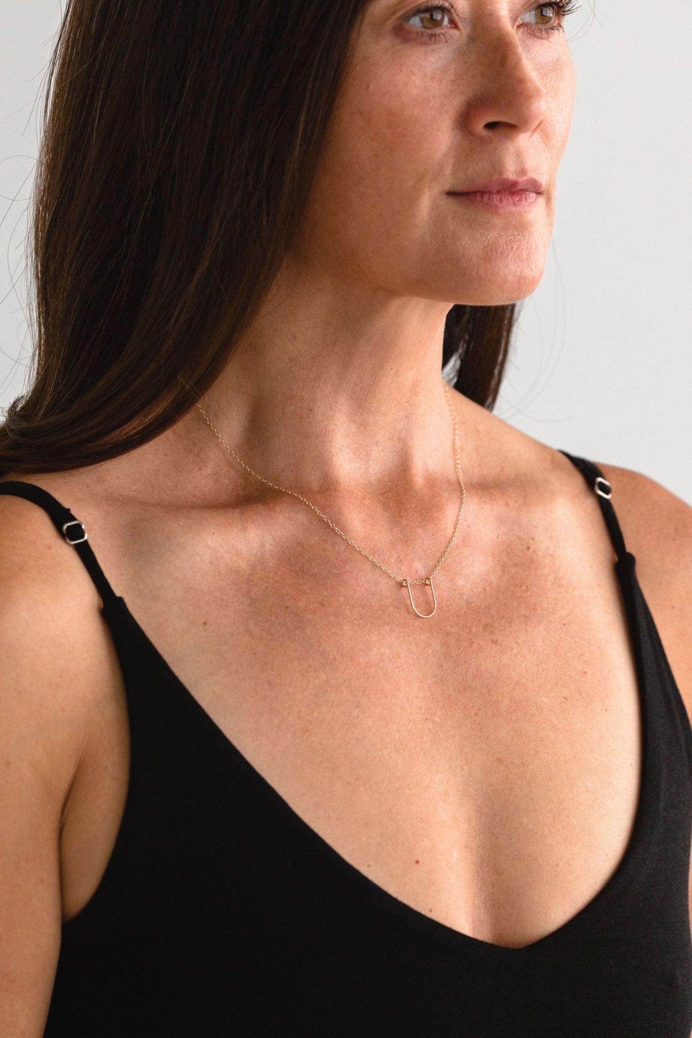 Gold-filled Empower Arch Necklace worn by a model, front view.