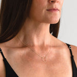 Gold-filled Empower Arch Necklace shown on model, side view.
