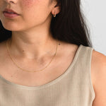 Gold fill satellite chain necklace worn by a model with neutral styling.