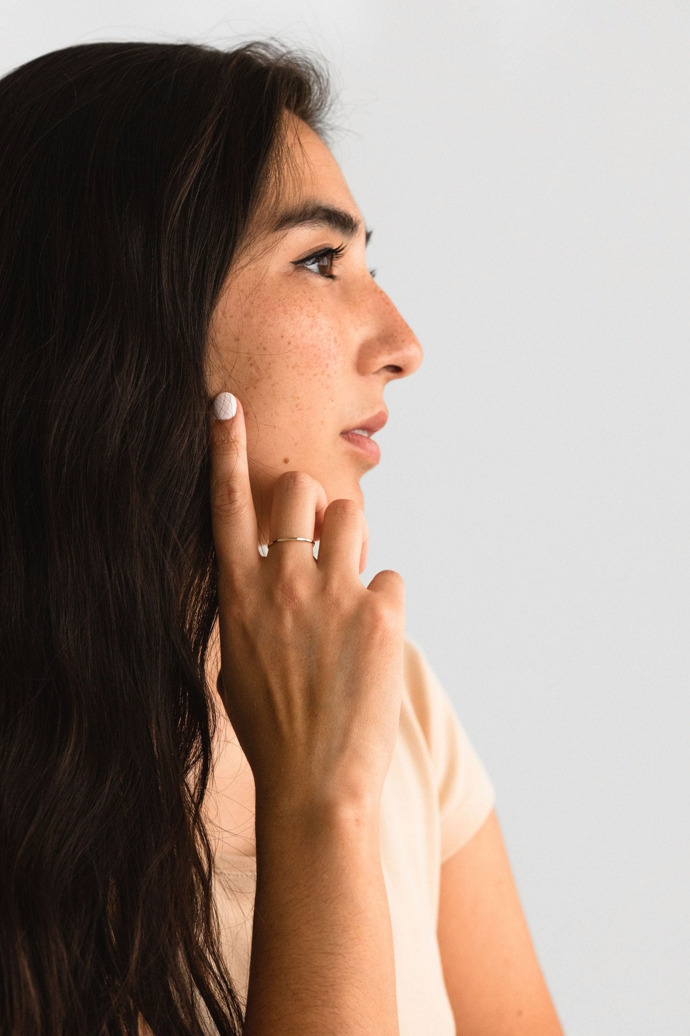 Model wearing the Hammered Ring in gold fill, styled as part of a delicate jewelry stack.