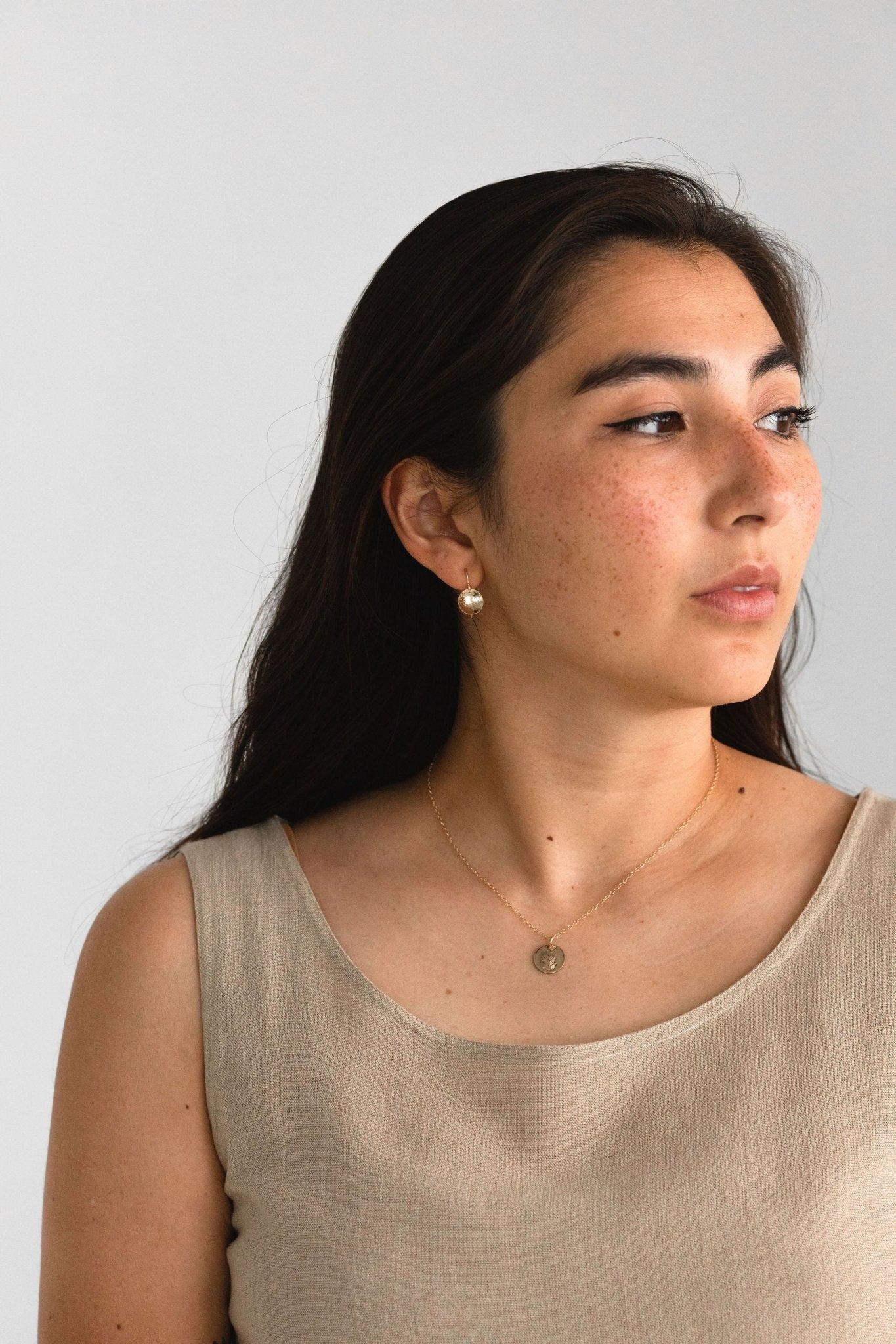Model wearing the Hygge Bloom Necklace in gold fill, reflecting a sense of mindfulness and connection.