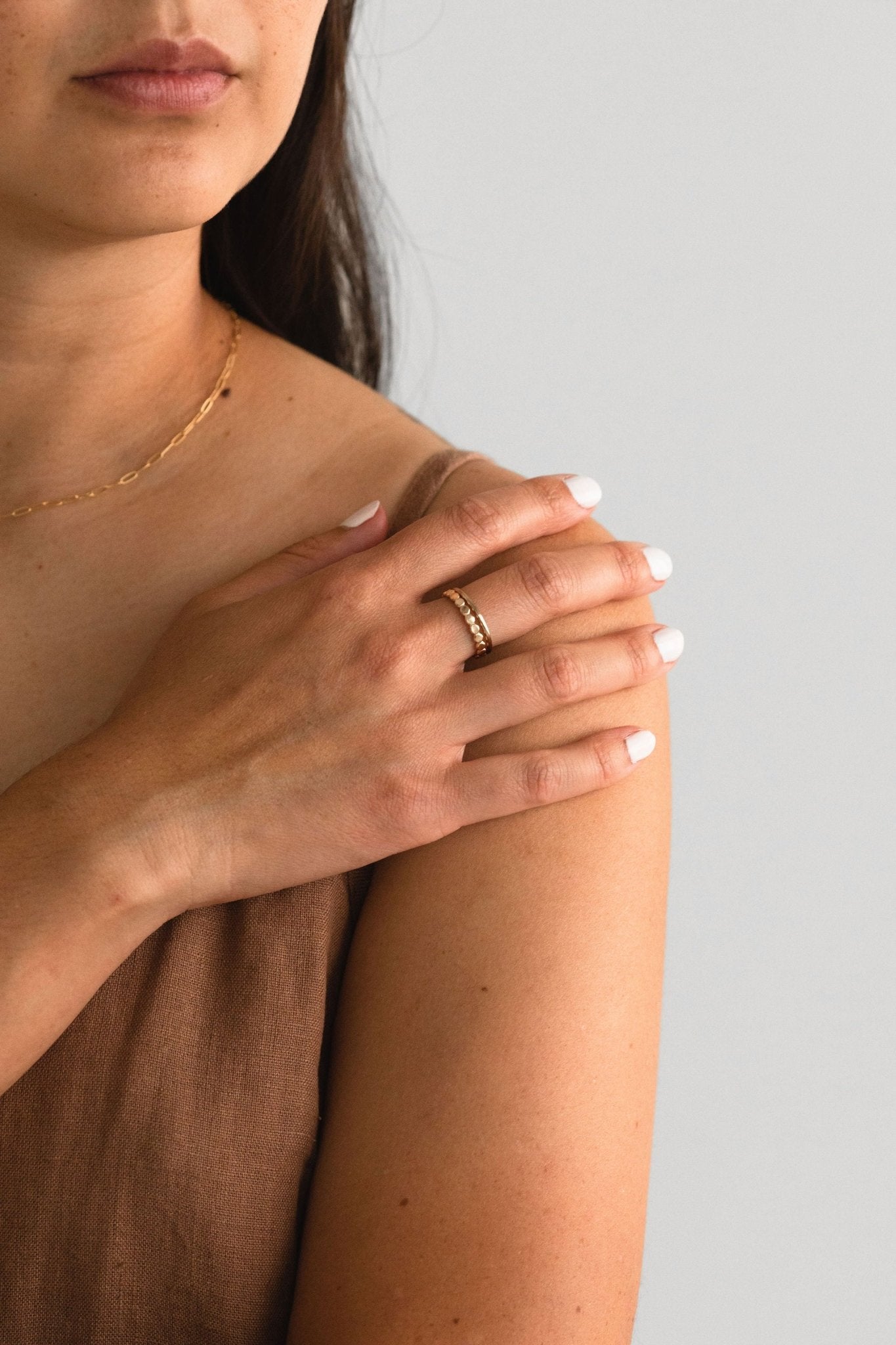 Model wearing Maeve 1.5mm round stacking ring gold fill stacked with other rings