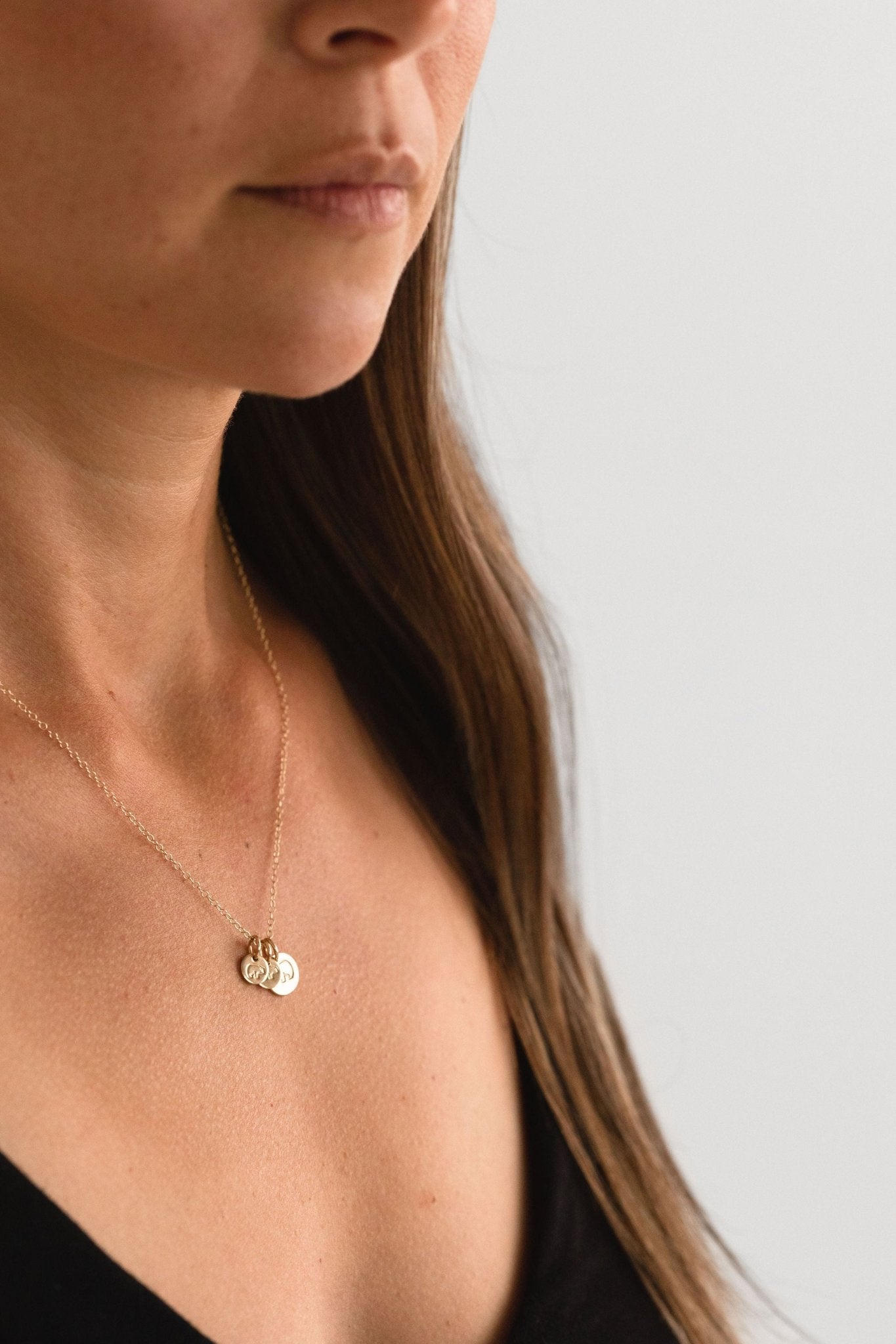 Mama Bear Baby Bear necklace layered with other delicate gold jewelry for a stylish look.