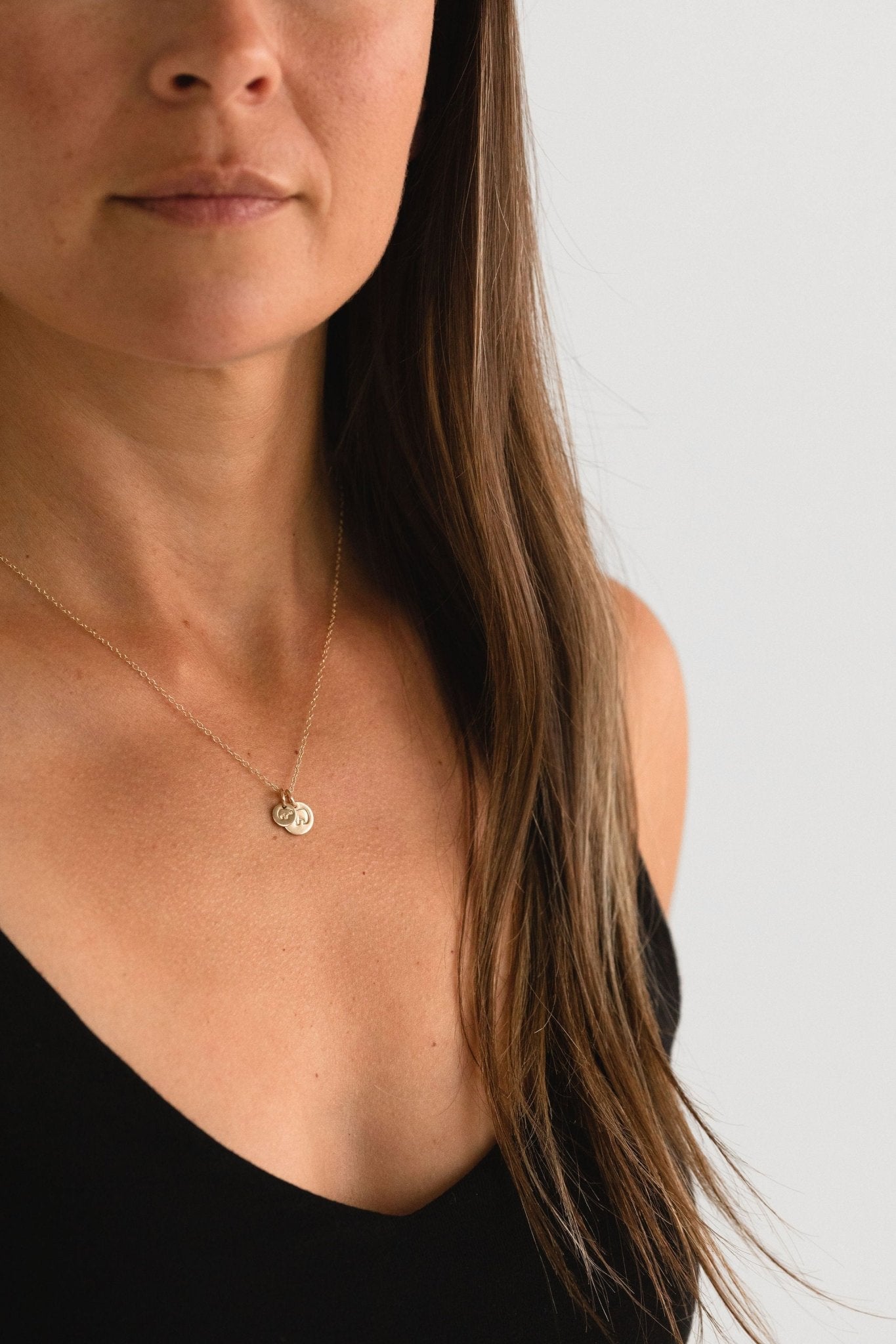 Model wearing Mama Bear Baby Bear necklace, hand-stamped with a gold fill heart-shaped pendant.