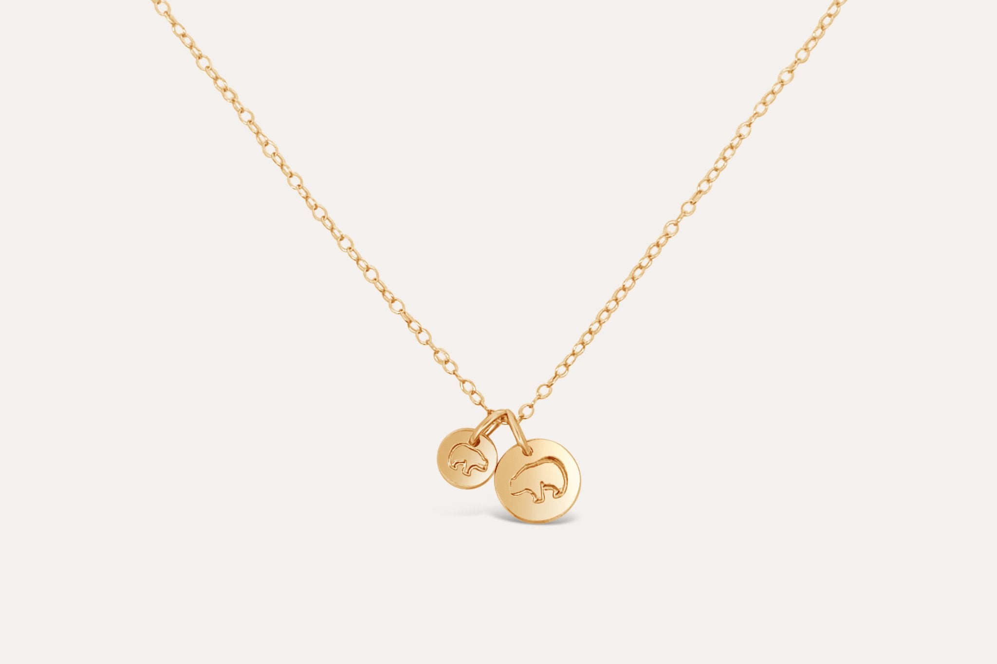 Mama Bear Baby Bear necklace layered with other delicate gold jewelry for a stylish look.