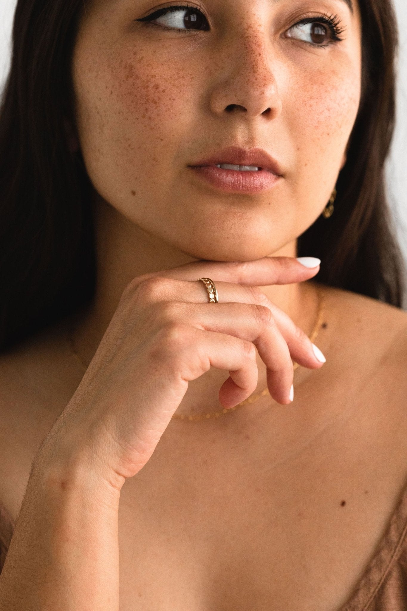 Woman wearing the Mirabelle Dot Band in gold fill on her finger.