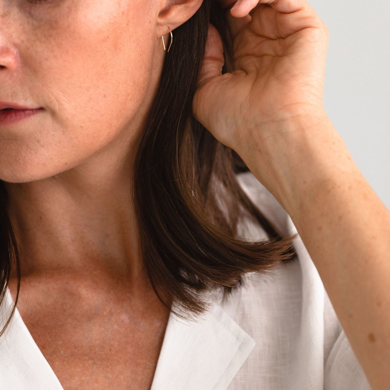 Woman wearing the Moab Arch Threader Earrings, showcasing their lightweight design and stylish fit.