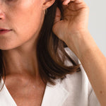 Woman wearing the Moab Arch Threader Earrings, showcasing their lightweight design and stylish fit.