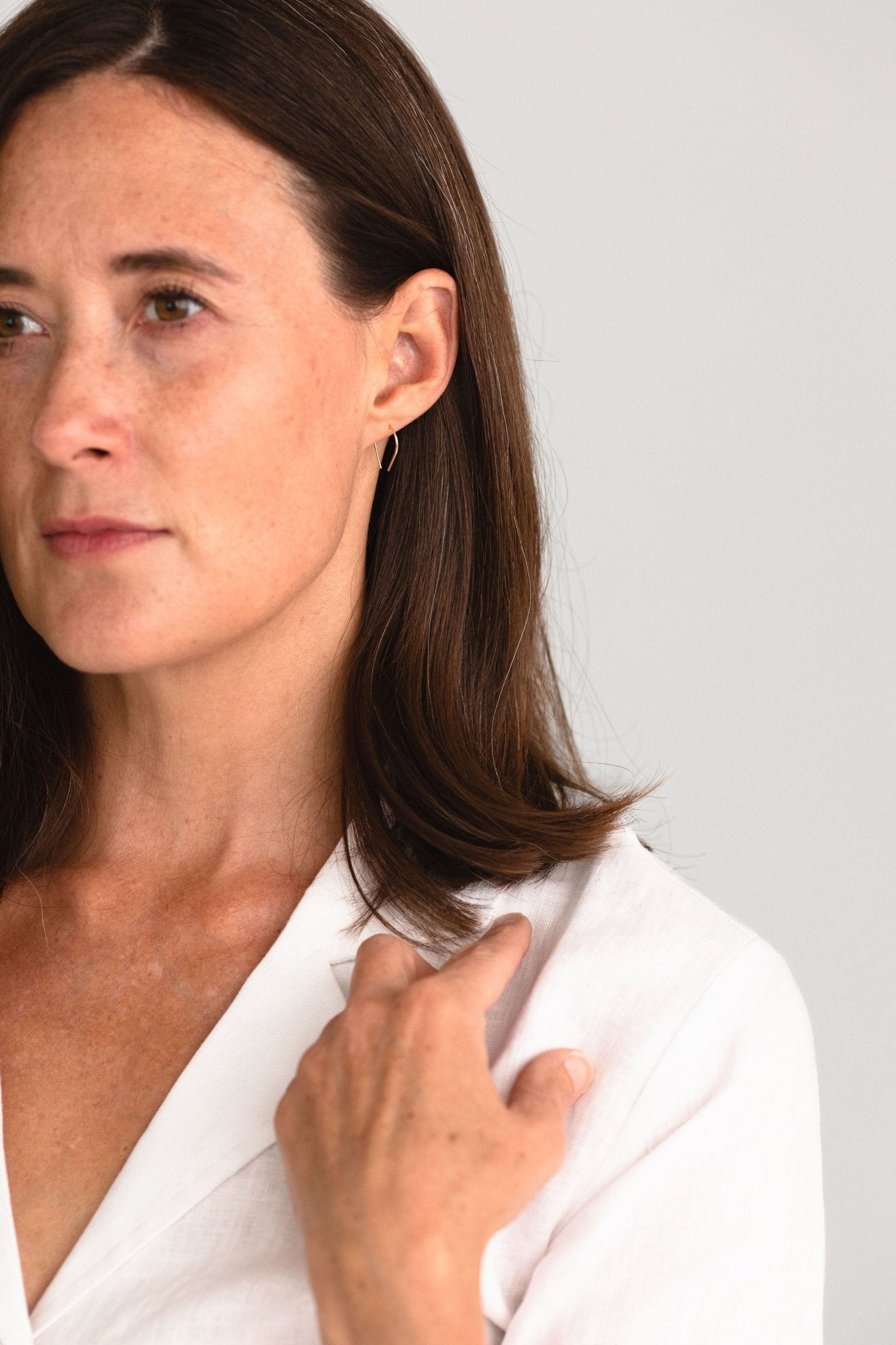 Moab Arch Threader Earrings styled with a white shirt for an elegant, everyday look.