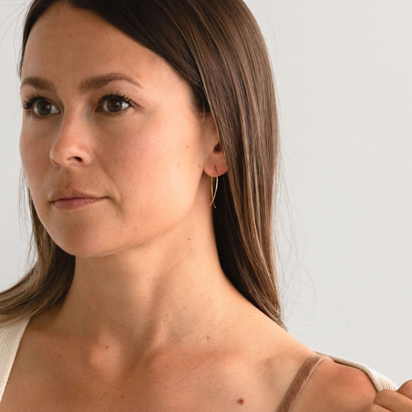 Woman wearing Poppy Threader Earrings made of gold fill, styled with a casual outfit.