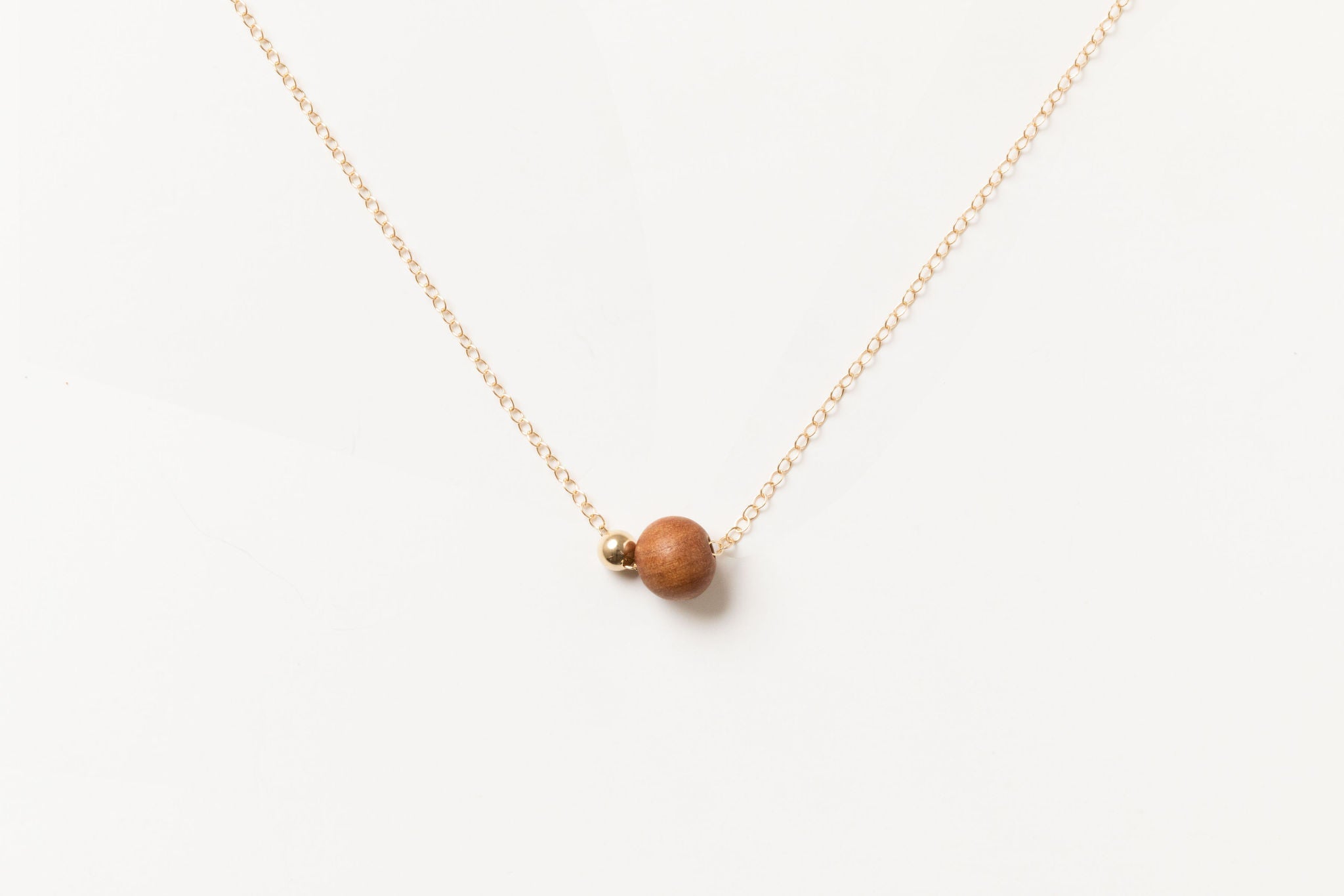 Handcrafted Sandalwood Bead Necklace by Sheena Marshall Jewelry featuring a 7mm ethically sourced sandalwood bead and 4mm gold-filled sphere on a delicate chain.